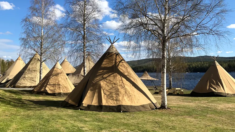 Tältkåtor uppställda på en gräsplan.