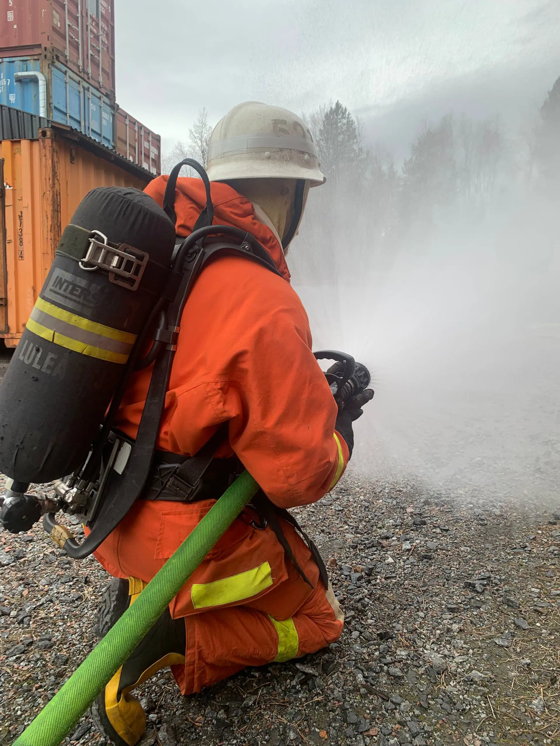 Brandman som sprutar vatten