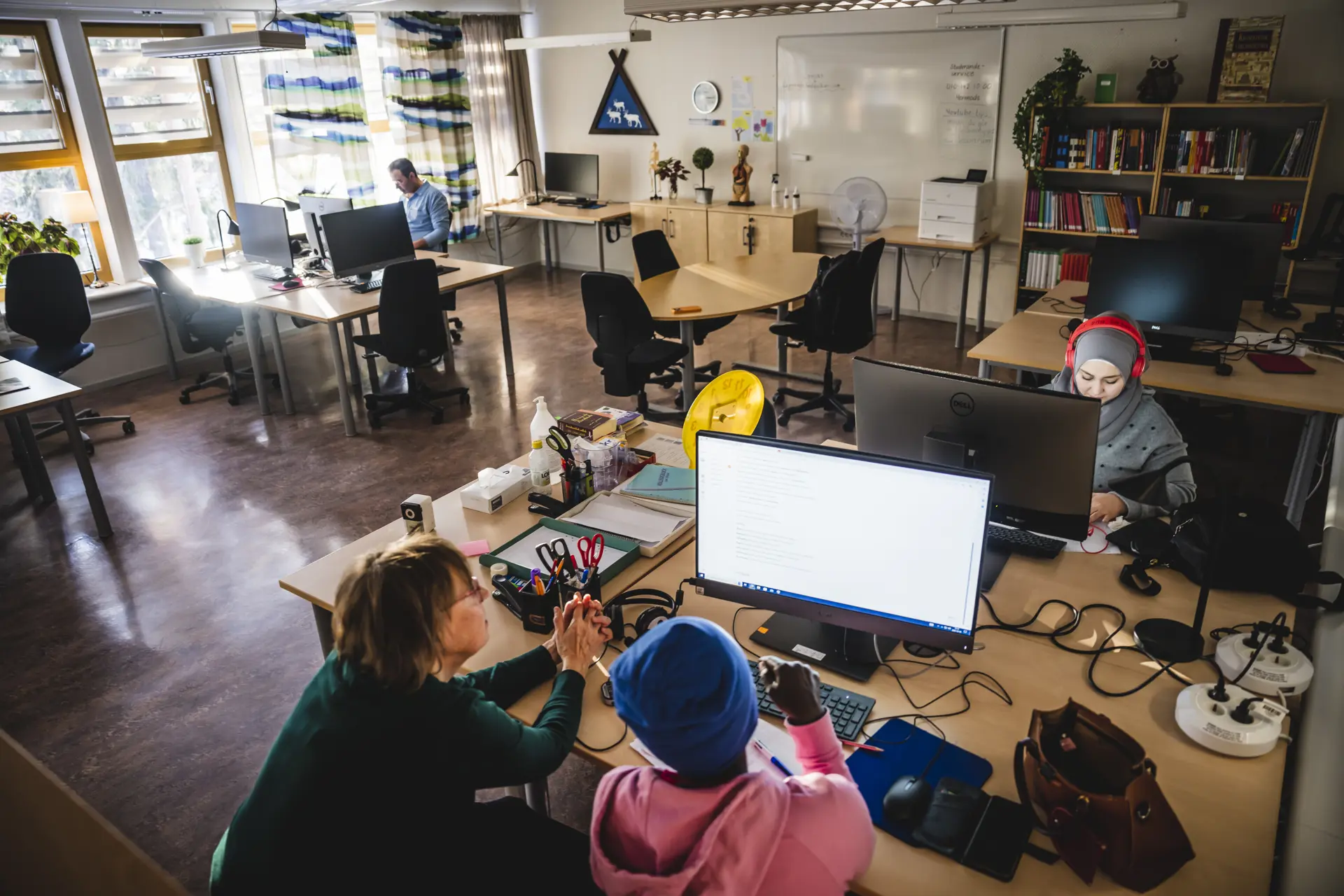 Klassrum med vuxna elever och personal vid datorer