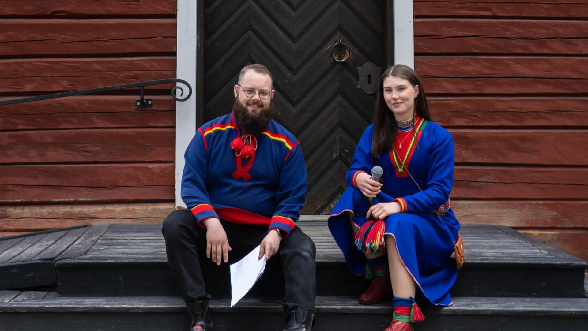 Juhán Niila Stålka och Astrid Tuorda sitter på trappen utanför Gamla kyrkan.